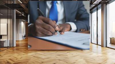 A businessman writing on paper is sitting on the desk. Wall mural