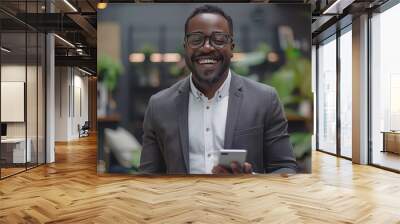 Happy businessman smiling with tablet, phone, and laptop inside the modern office. Wall mural