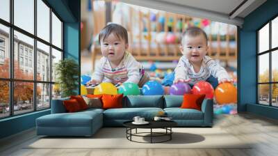 two toddlers playing with balls and a xylophone sitting on the floor at the kindergarten. Wall mural