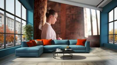 Vintage photo of teenage girl in a retro Thai dress at the famous Phra Singh Temple in Chiang Mai Province. Wall mural