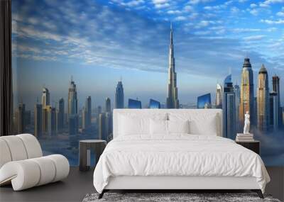 A stunning view of Dubais skyscrapers emerging from a blanket of morning fog, with a clear blue sky above Wall mural