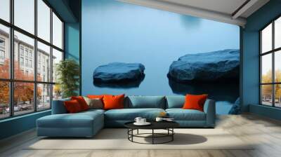 Two smooth rocks rest partially submerged in still water, reflecting a tranquil blue hue at twilight Wall mural