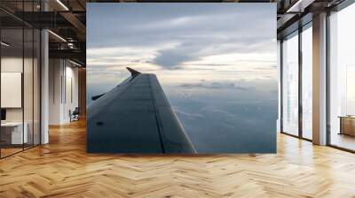 The airplane wing on the beautiful cloudy and sky at early in the evening. Wall mural