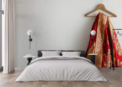 A bold red and gold saree with traditional patterns, draped on a wooden hanger against a minimalistic white wall. Wall mural