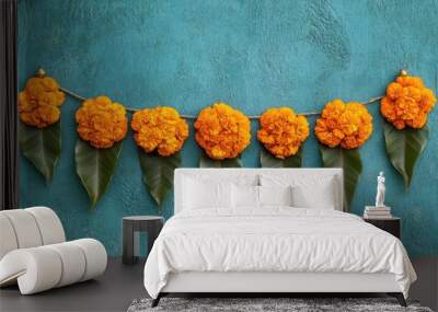 A decorative toran with marigold flowers and mango leaves, hanging beautifully against a plain surface for Diwali. Wall mural