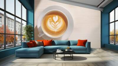 Top view of a coffee cup with latte art on a light wooden table, exuding a calming morning vibe. No logo, no people. Wall mural