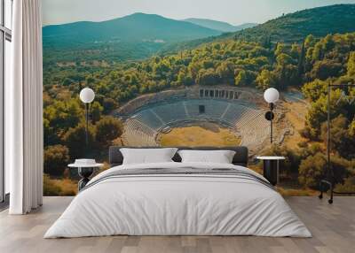 Top view of the Epidaurus Theater, a circular ancient Greek amphitheater amidst green hills and forests Wall mural