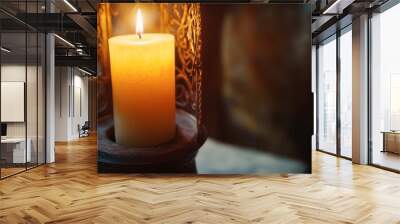 A candle burning in a lantern, with the light softly illuminating the glass and casting patterns on the walls. Wall mural