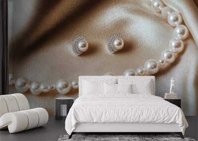 A flat-lay of a pearl necklace and matching earrings, arranged on a soft velvet background. Wall mural