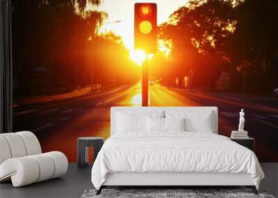 A traffic light with the sun setting behind it, casting long shadows on the road. Wall mural