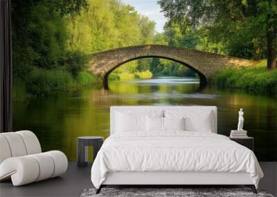 A view of an old stone bridge crossing a serene river, with surrounding trees and greenery reflecting in the water. Wall mural