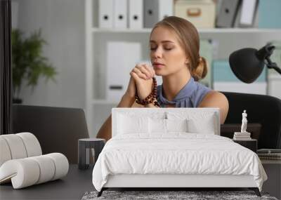 Beautiful young woman praying in office Wall mural