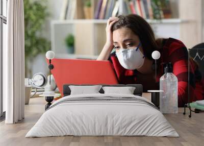 Bored student looking laptop in coronavirus confinement Wall mural