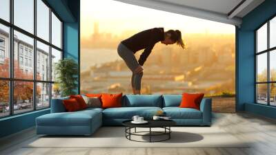 Exhausted runner resting after running in city outskirts Wall mural