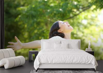 Happy adult woman breathing fresh air in the park Wall mural