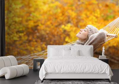 Relaxed woman lying on hammock in autumn forest Wall mural