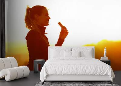 Silhouette of runner eating energy bar after running Wall mural