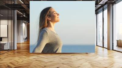 Woman breaths fresh air on the beach Wall mural