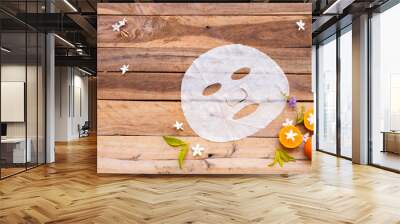 natural aroma sheet mask extract fruit orange health care for skin face essence face mask and flower arrangement flat lay style on background wooden Wall mural