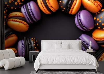 Vibrant macarons in Halloween colors--orange, black, and purple--decorated with spooky designs, surrounding a blank text space for holiday messages. Wall mural