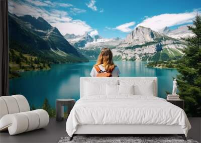 Travel background concept. The back view of the woman looking and the beautiful landscape with the lake or the river, mountains covered in snow, trees in the summer Wall mural