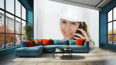 Young engineer woman with safety hard hat talking on phone Wall mural