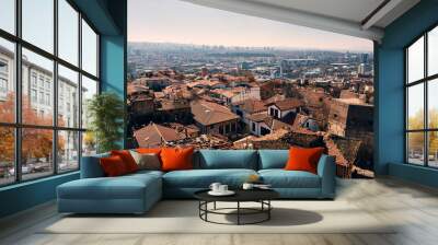 Panoramic view of tiled rooftops of historical residential buildings at foreground and modern high-rise buildings at background. Panoramic view of Ankara city as seen from Ankara citadel Wall mural