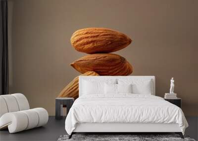 Product shoot of a stack of fresh almonds arranged on a brown surface. Wall mural