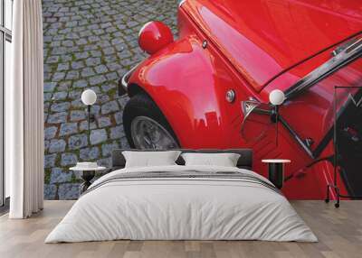 High angle shot of a red car bonnet and a wheel parked on the street Wall mural