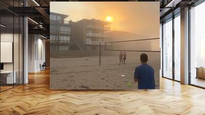 Vibrant sunset overcrowded beach scene with enthusiastic volleyball players enjoying the evening Wall mural