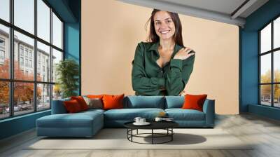 color field style HDR photo of breathtaking Photo portrait of folded arms young woman in green shirt business investor satisfied glad receptionist isolated on beige color background ,brown jean pant,  Wall mural