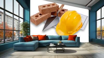 A set of house building bricks and trowel, with a yellow hard hat, on a set of building plans, isolated on  white with a drop shadow Wall mural