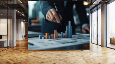 A business professional analyzing data charts with bar graphs, symbolizing market trends and financial strategies. Wall mural