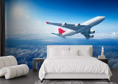 Airplane flying above clouds Wall mural