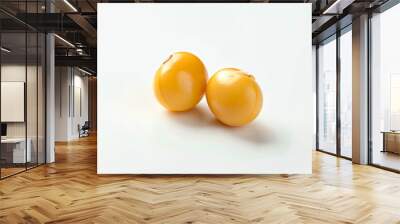 two yellow fruit sitting on top of a white surface Wall mural