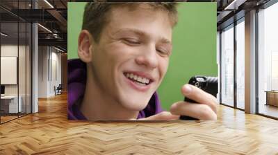 Closeup of a teenager using smart phone and smiling Wall mural