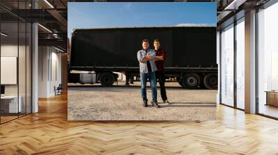 Father and son together starting trucking business, standing proudly in front of long hail truck with trailer  Wall mural