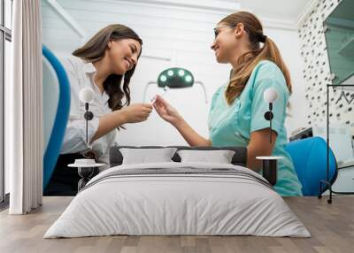 Female dental doctor giving her patient toothbrush  Wall mural