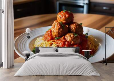 Close up image of a white ceramic plate spaghetti and meatballs centered on a wooden table, with a blurred kitchen background Wall mural