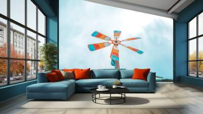 Colorful vintage cute iron wind turbine on the wooden roof. Wall mural