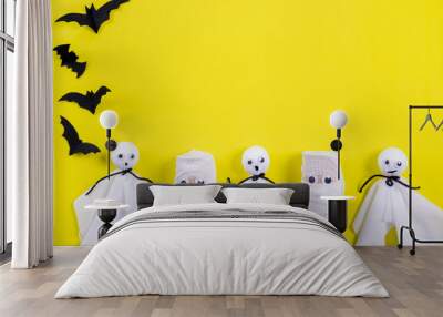 Top view of Halloween crafts, DIY paper ghost on yellow paper background with copy space for text. Halloween concept. Wall mural