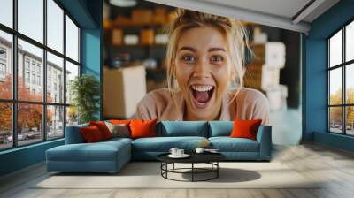 A Young blonde woman working in a small e-commerce business Her wild and surprised celebration with wide eyes. and screamed with excitement at the success Wall mural