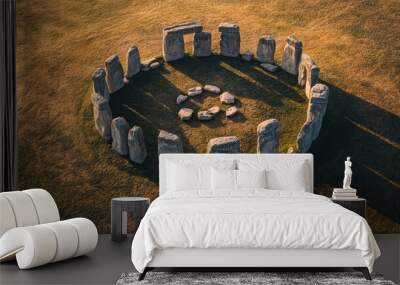 Drone shot of Stonehenge, capturing the stone circle from above, emphasizing its circular layout, against a backdrop of soft earth tones and minimal detail. Wall mural