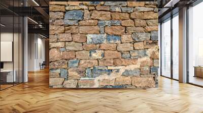 Close-up of a rugged stone wall showcasing natural textures and color variations. The image captures the rustic and timeless appeal of traditional masonry work. Wall mural