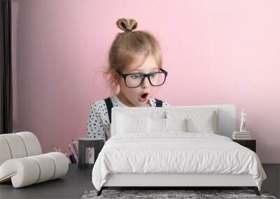 Litttle girl lookinLitttle girl looking at laptop screen with expression of surprised and excitement. Smart, smilling little girl taking notes . Communication in business concept. Wall mural