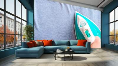 Her woman's hHand of woman her rolled blue clothes.Fashion conceptand is ironed on clothes. Wall mural