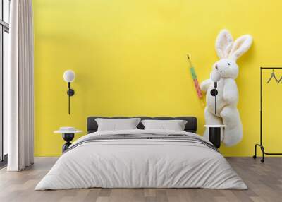 Children's toy with a medical thermometer. Soft toy hare and medical thermometer on a yellow background. Chills in children. Temperature measurement in children. Flat lay. View from above. Copy space Wall mural