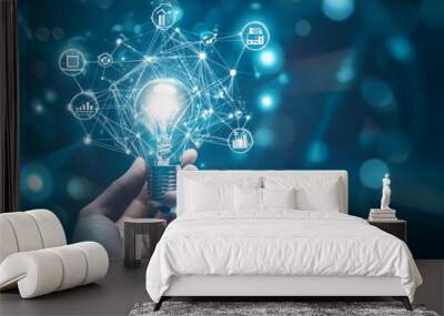 A hand holds a glowing light bulb connected to a network of digital icons, representing innovative ideas
 Wall mural