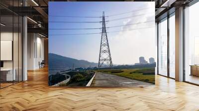 The high voltage poles are under the blue sky and white clouds Wall mural