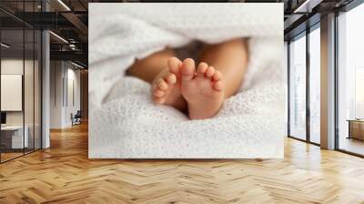 Adorable baby feet covered in a white blanket, maternity and babyhood concept Wall mural